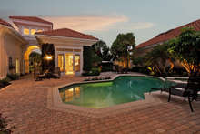 Looking east towards the guest cabana from the home's entry. Pool area has a southwest exposure. (Landscape lighting seen in distance is illustrated to show possibility.)