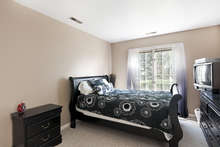 Located on the entry level, this carpeted bedroom has its own attached bath, as well as oversized windows and a large closet. 