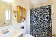 The attached bath has a shower and wooden medicine cabinet. 