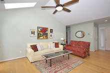 Hardwood floors gleam under the light from the skylights. The living area also features a large new wooden ceiling fan. 